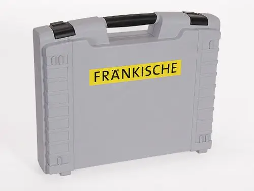 Grauener Werkzeugkoffer mit schwarzem Griff und gelbem Aufkleber "Fränkische". Der Koffer ist leer und hat eine strukturierte Oberfläche mit seitlichen Rillen.